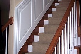 Raised Panel Wainscoting Staircase with Top Cap Molding mitered down the side of the panel about 1/2 inch from the corner