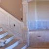 At the top of this staircase the wainscoting panel goes vertical and the top cap molding is mitered to match the elevation of the panel on the other side of this corner. 