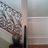 Staircase Raised Panel Wainscoting on a staircase that does not have a stringer. Beautiful Iron Railing.